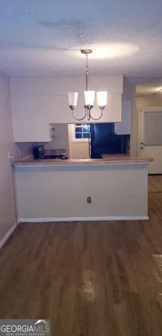 a view of a kitchen with a sink and chandelier