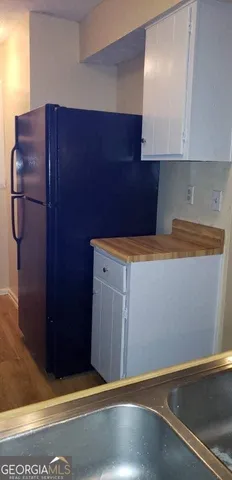 a kitchen with granite countertop white cabinets and a wooden floor
