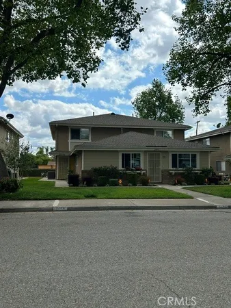 a yellow house with trees in front of it