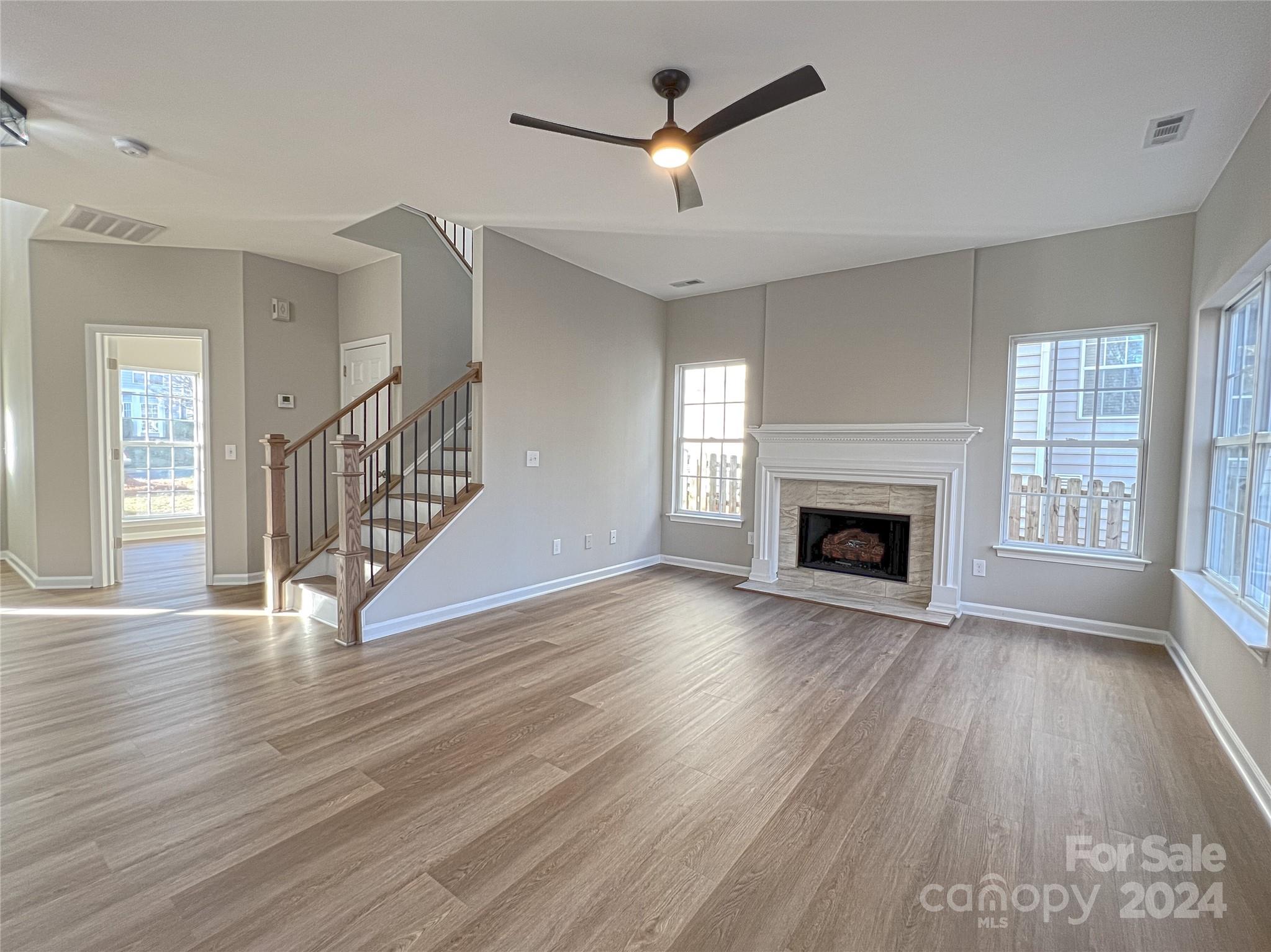 1644 Heather Glen Road Kannapolis, NC 28081 - Photo 8 of 25 an empty room with wooden floor fireplace and windows