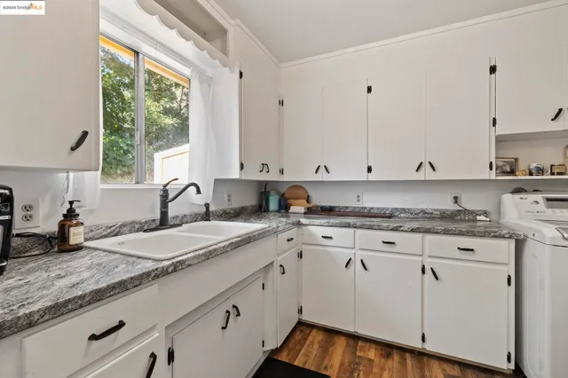 a kitchen with granite countertop white cabinets and white appliances