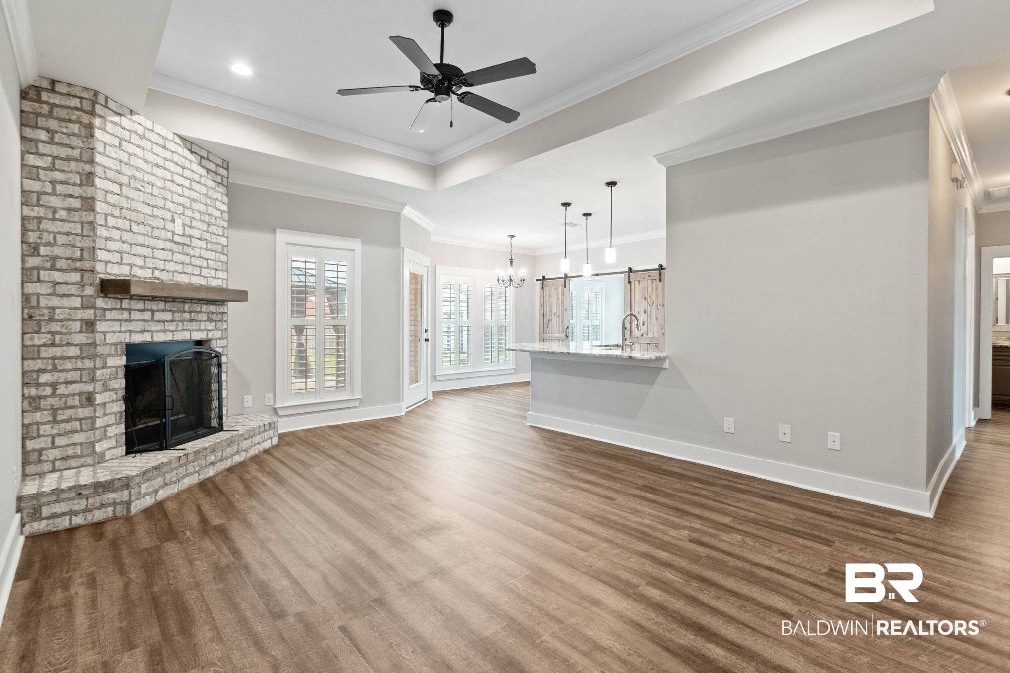 17376 Bankhead Boulevard Fairhope, AL 36532 - Photo 13 of 73 Unfurnished living room featuring a chandelier, a fireplace, dark wood-type flooring, ornamental molding, and a ceiling fan