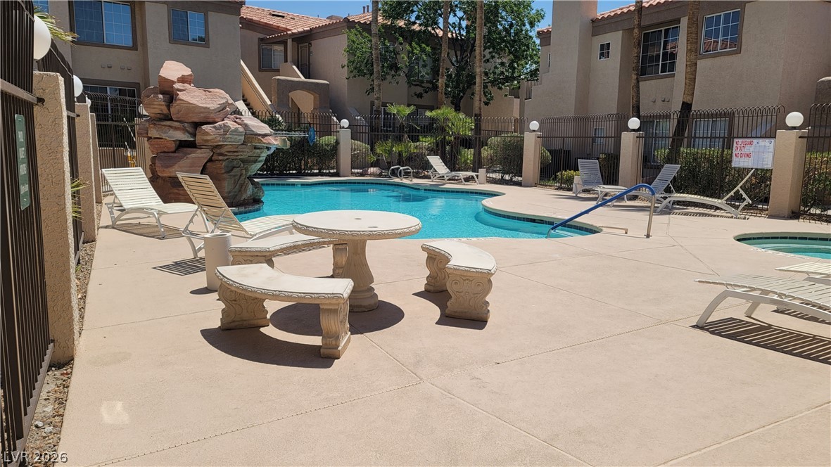 1851 Hillpointe Road, Unit 1022 Henderson, NV 89074 - Photo 5 of 8 A refreshing pool area with a unique rock waterfall feature, ideal for leisure and relaxation.