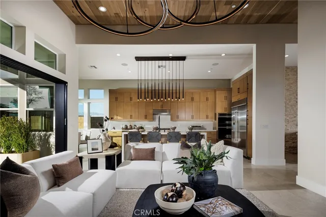 a living room with furniture a chandelier and a large window