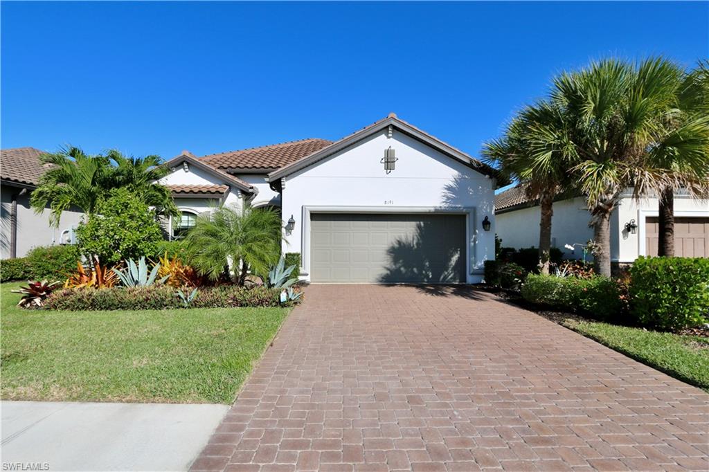 a front view of a house with a yard and potted plants
