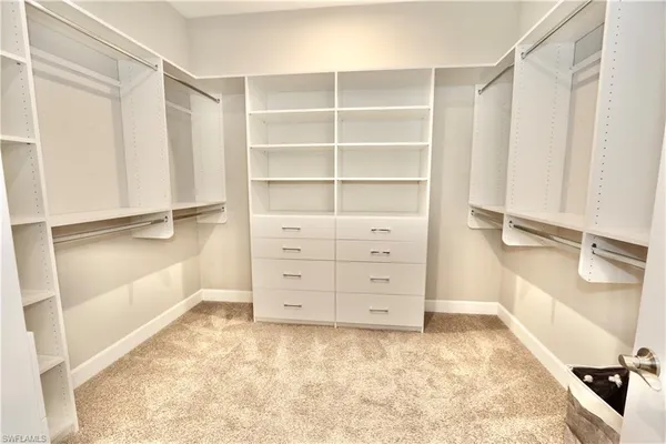 a view of walk in closet with clothes and shoes