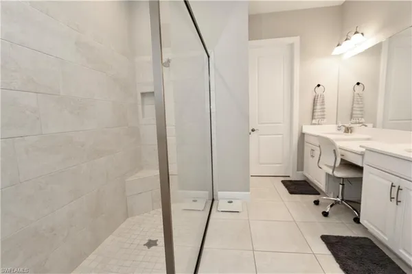 a spacious bathroom with a double vanity sink a mirror and a shower