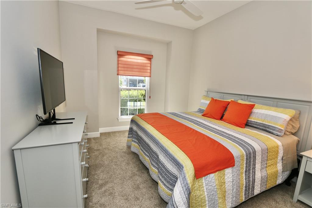 8191 Lucello Terrace North Naples, FL 34114 - Photo 20 of 42 a bedroom with bed and a flat tv screen on dresser