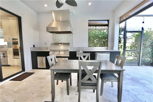 a kitchen with granite countertop a table chairs stove and cabinets