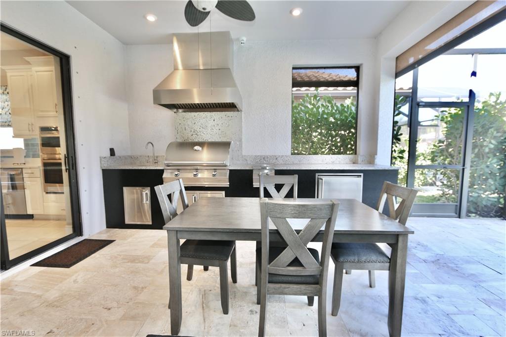 8191 Lucello Terrace North Naples, FL 34114 - Photo 25 of 42 a kitchen with granite countertop a table chairs stove and cabinets