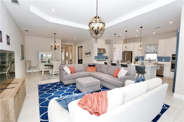 a living room with lots of furniture and kitchen view