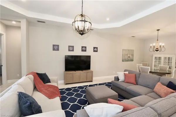a living room with furniture ceiling fan and a flat screen tv