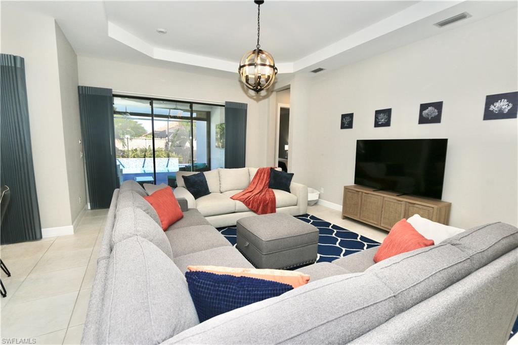 8191 Lucello Terrace North Naples, FL 34114 - Photo 9 of 42 a living room with furniture a flat screen tv and a large window