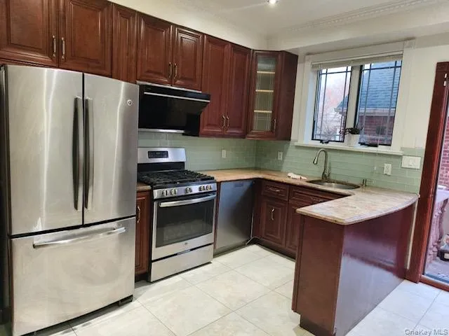 a kitchen with granite countertop a refrigerator and a sink