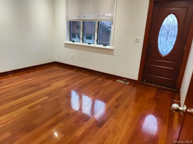 a view of a room with wooden floor and a window