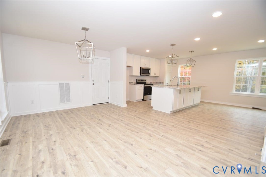 375 Amick Road Louisa, VA 23093 - Photo 3 of 25 a view of a kitchen with kitchen island a sink wooden floor and counter top space