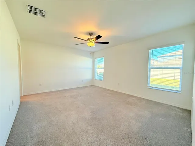 an empty room with closet and windows