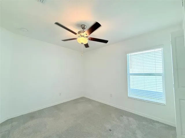 a view of a livingroom with a ceiling fan and window