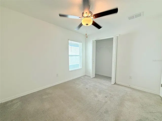 a view of a livingroom with a ceiling fan and window