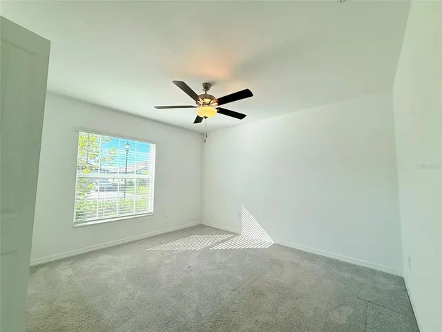 a view of an empty room with a ceiling fan