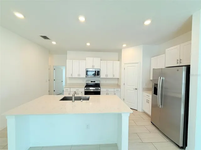 a kitchen with a sink a stove and cabinets