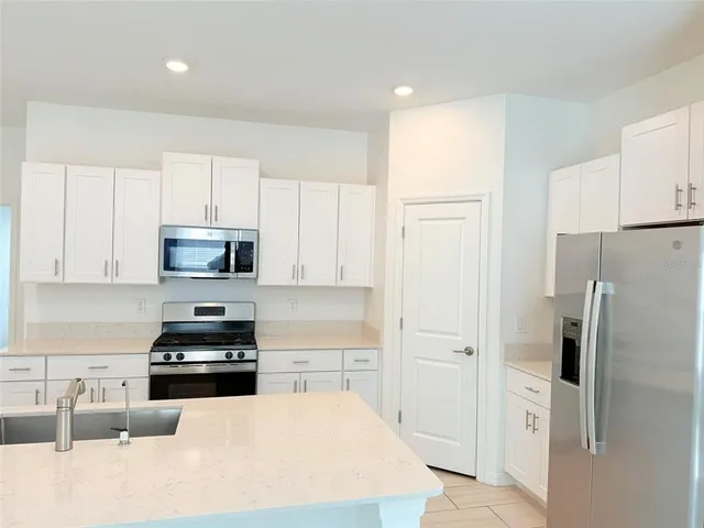 a kitchen with a sink a stove a refrigerator a microwave and cabinets