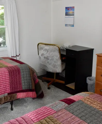 a bedroom with a bed and painting on the wall