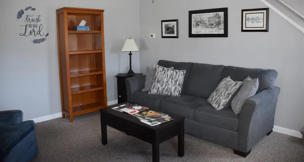 a living room with furniture and a wall painting