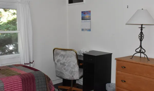 a bedroom with a bed a desk and chair