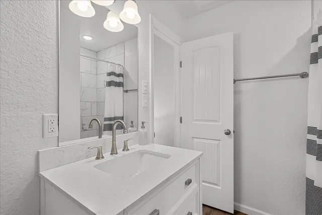 a bathroom with a sink vanity and a mirror