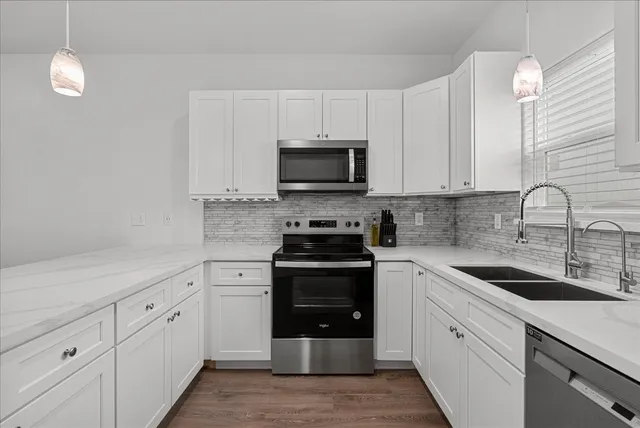 a kitchen with white cabinets and stainless steel appliances