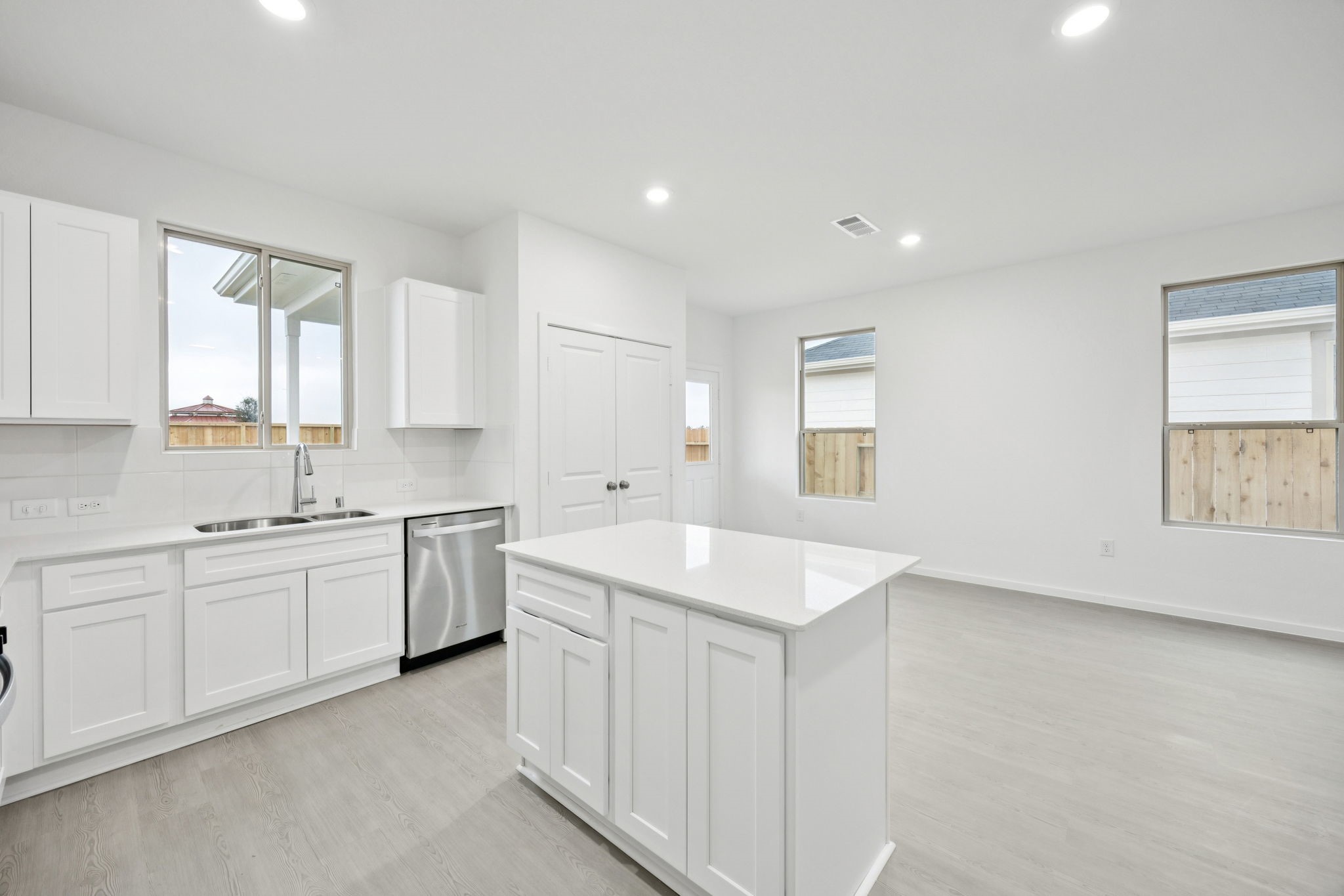 414 Point Nemo Street Crosby, TX 77532 - Photo 29 of 50 a kitchen with sink a stove and white cabinets