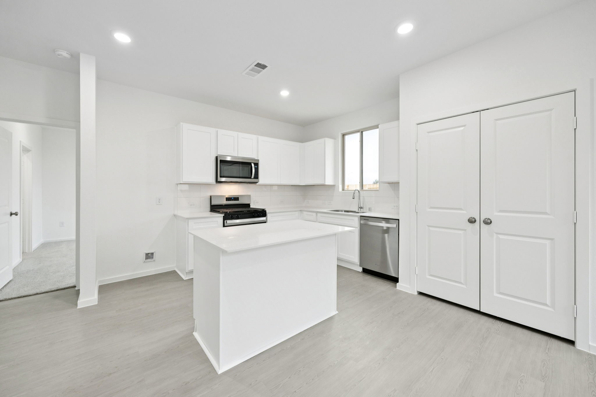414 Point Nemo Street Crosby, TX 77532 - Photo 7 of 50 a kitchen with white cabinets and stainless steel appliances