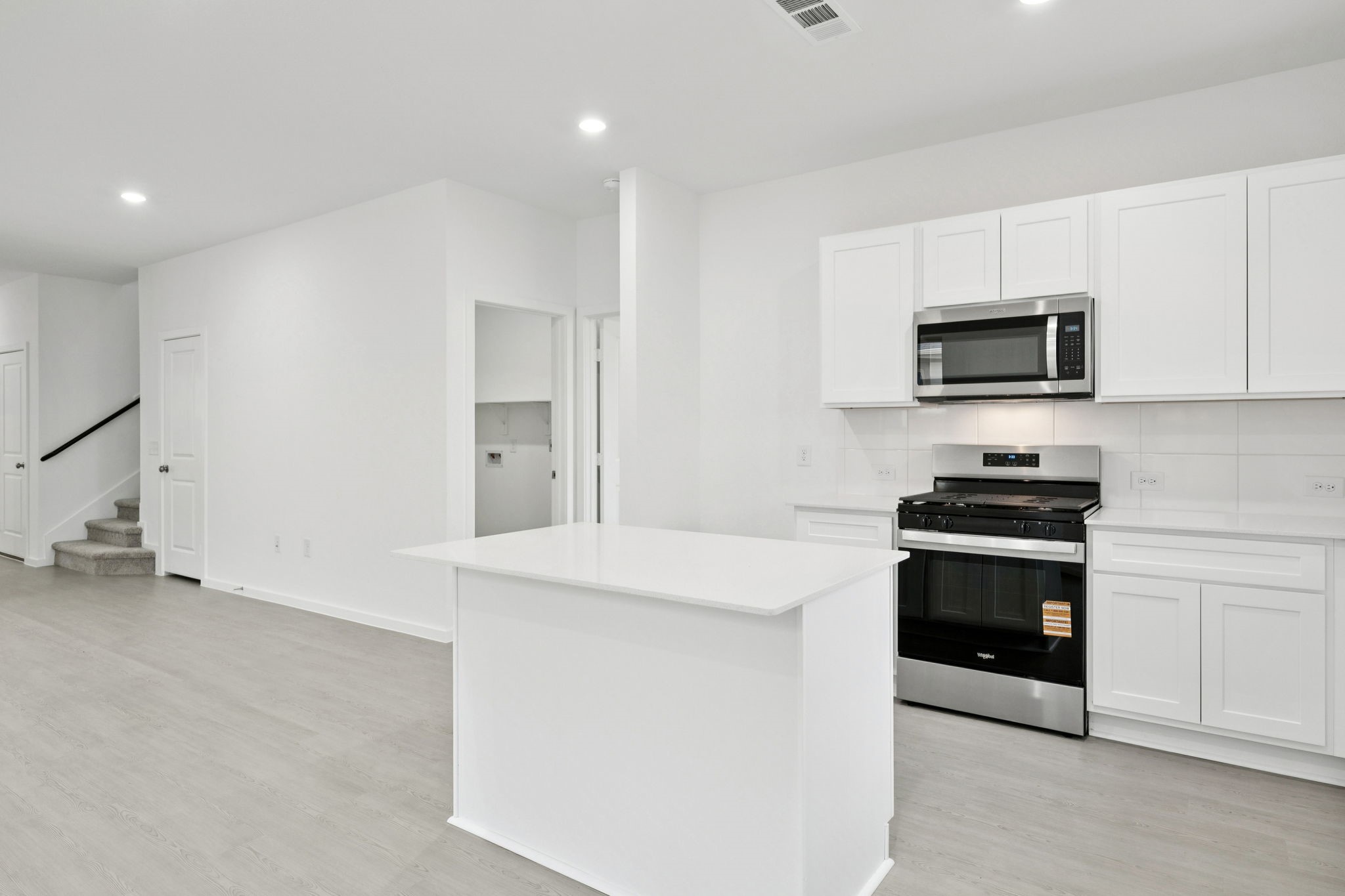 414 Point Nemo Street Crosby, TX 77532 - Photo 8 of 50 a kitchen with stainless steel appliances a stove a microwave and white cabinets