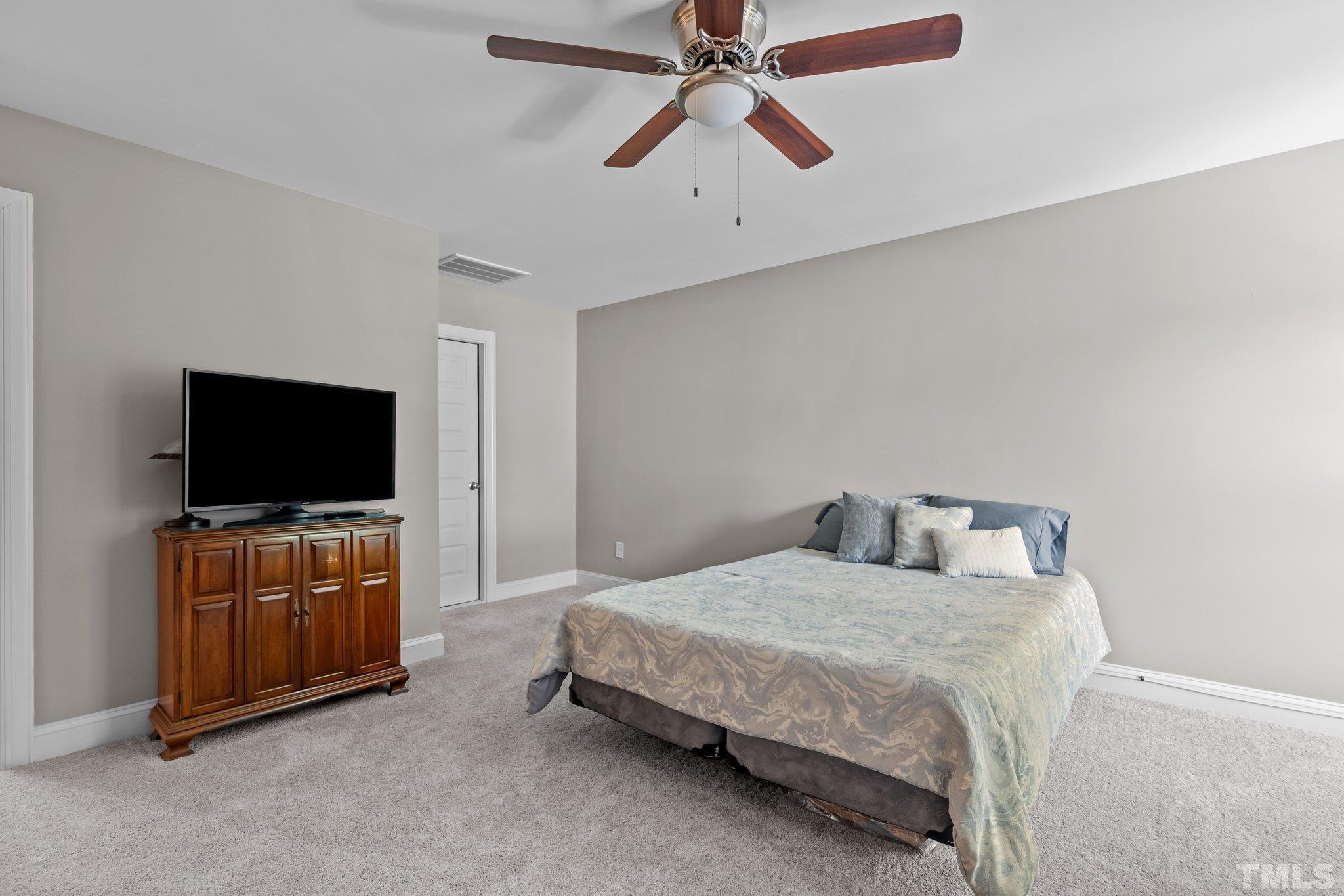 391 River Ridge Lane Timberlake, NC 27583 - Photo 30 of 47 a bedroom with a bed and a flat screen tv