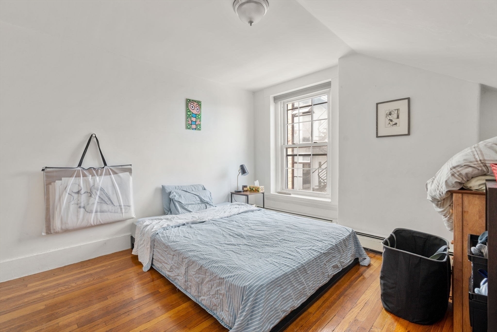 343 Harvard Street Cambridge, MA 02138 - Photo 10 of 41 a bedroom with a bed and wooden floor