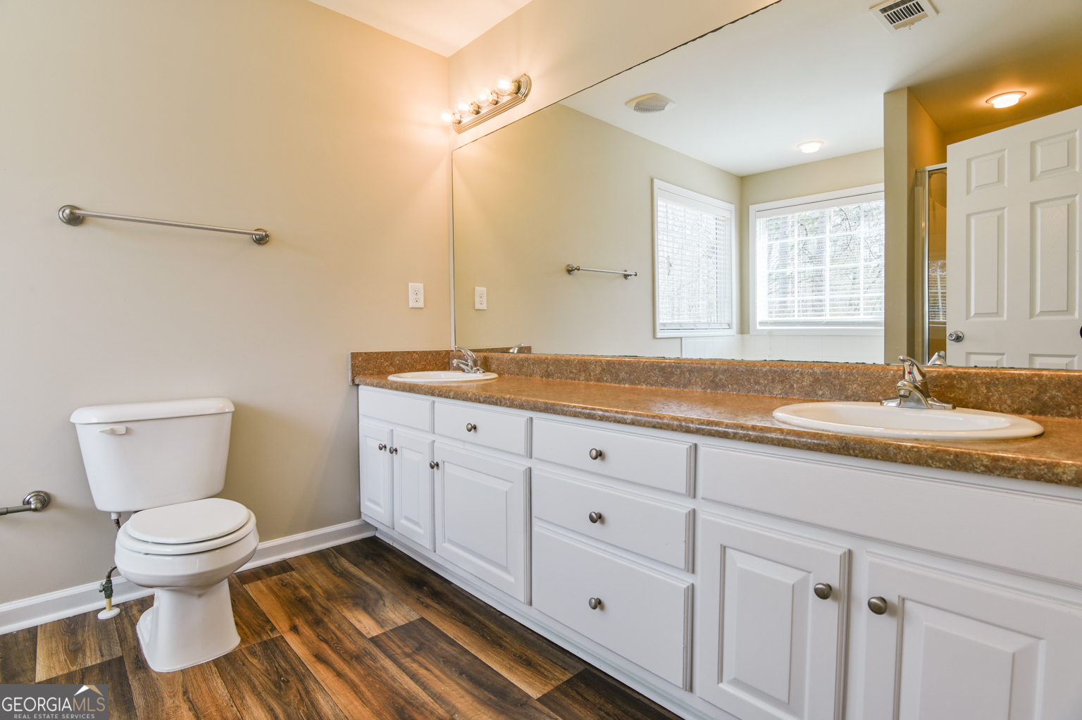 1766 Laurel Ridge Drive Southwest Conyers, GA 30094 - Photo 19 of 61 a bathroom with a granite countertop toilet sink and mirror