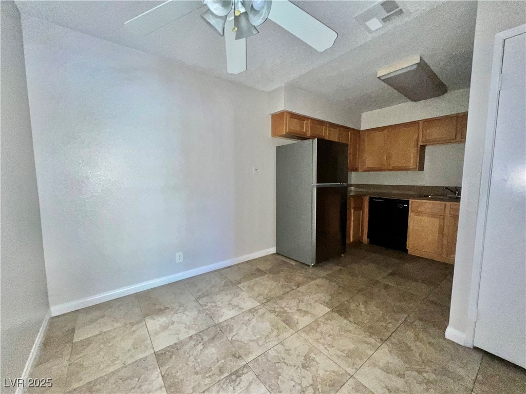 3151 North Soaring Gulls Drive, Unit 1150 Las Vegas, NV 89128 - Photo 6 of 17 Kitchen featuring black appliances, dark countertops, ceiling fan, and brown cabinets