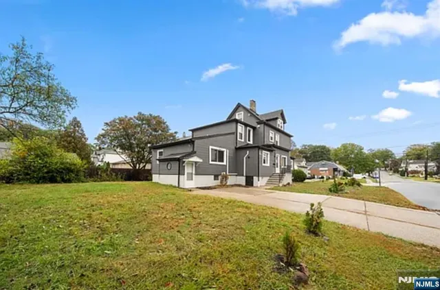 a front view of a house with a yard and mountain view