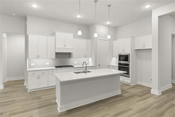 a kitchen with kitchen island a sink stainless steel appliances and cabinets