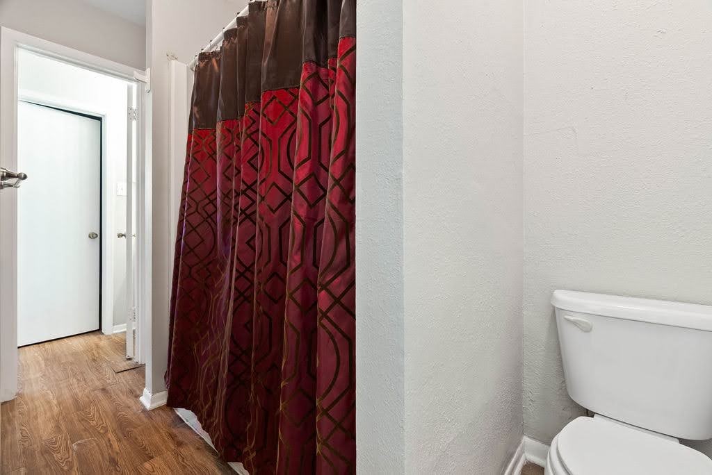 1410 Moore Avenue Portland, TX 78374 - Photo 11 of 17 a white toilet sitting next to a shower curtain