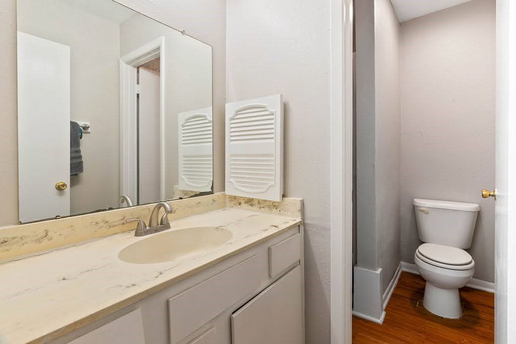 1410 Moore Avenue Portland, TX 78374 - Photo 10 of 17 a bathroom with a granite countertop sink toilet and a mirror