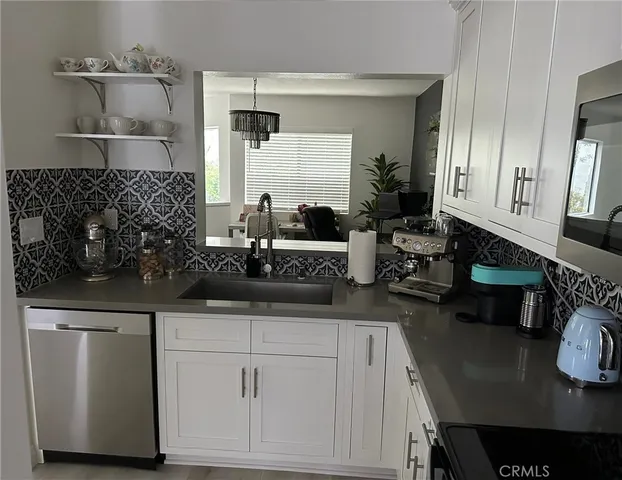 a kitchen with white cabinets and sink