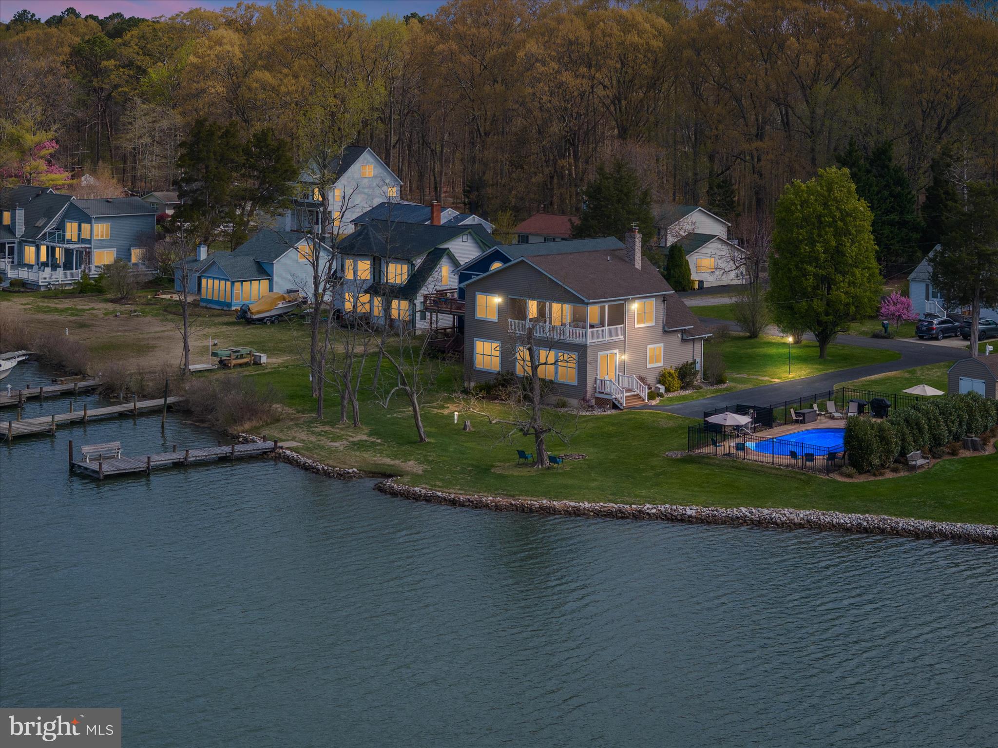 a front view of a house with a yard and lake view