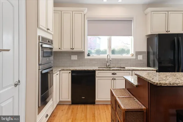 a kitchen with granite countertop a sink and a stove top oven