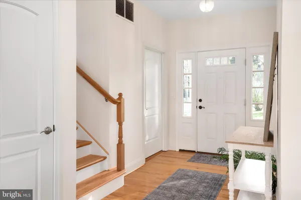 a view of an entryway with wooden floor and a livingroom