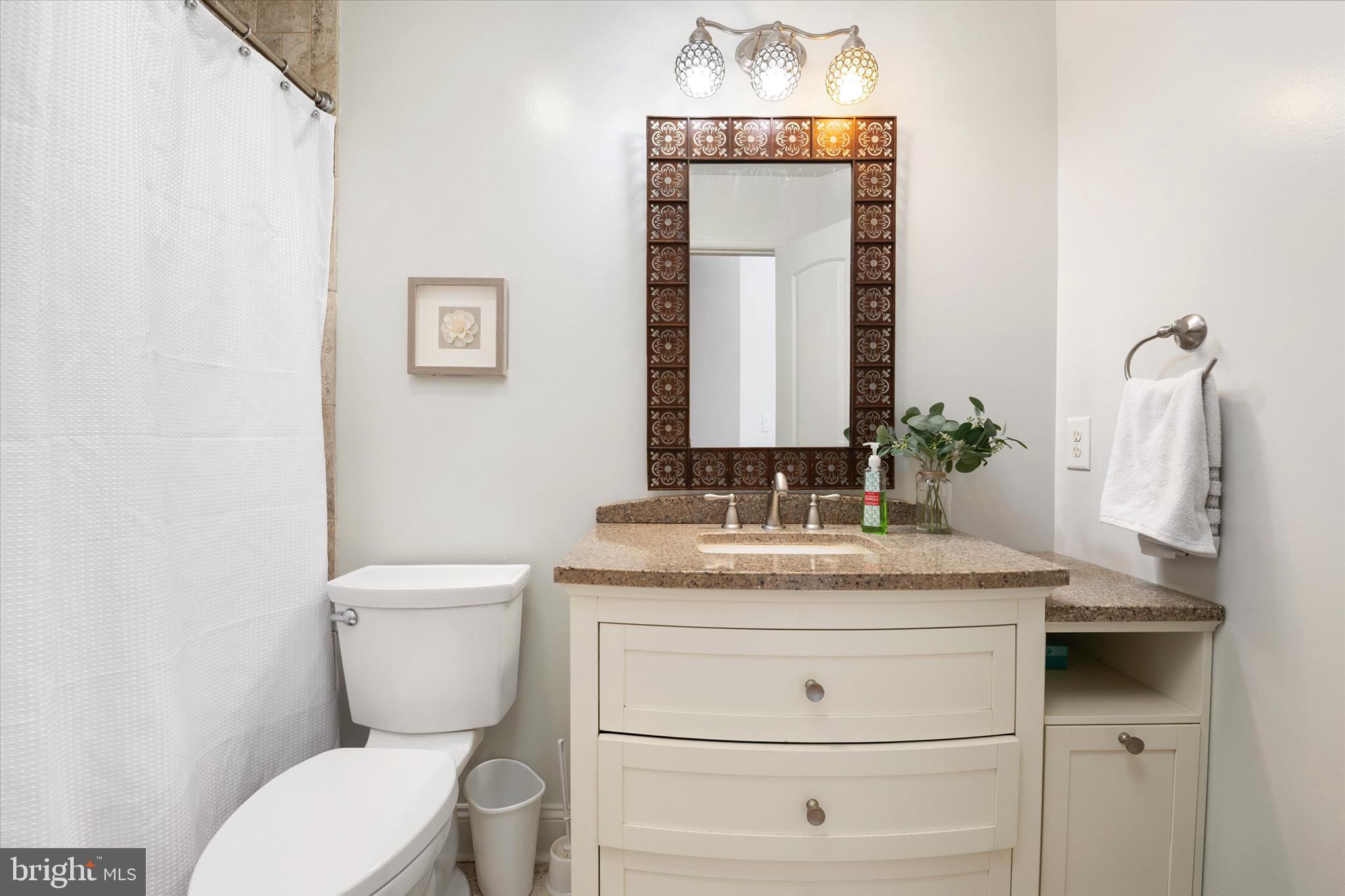 5936 Sneed Drive Deale, MD 20751 - Photo 32 of 59 a bathroom with a granite countertop toilet sink and mirror