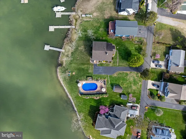 an aerial view of ocean and residential houses with outdoor space