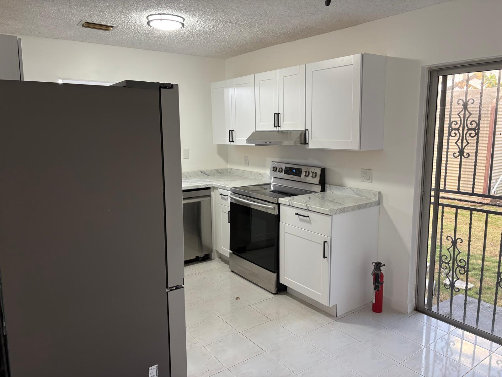 12231 Southwest 210th Street Miami, FL 33177 - Photo 20 of 38 a kitchen with a stove sink and a refrigerator