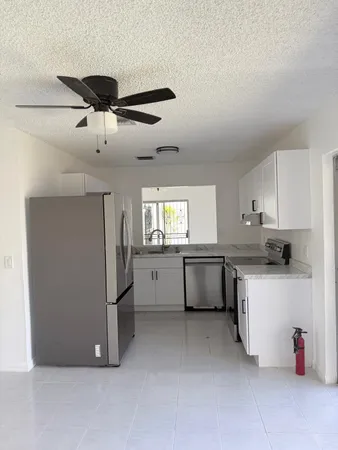 a kitchen with a refrigerator and white cabinets